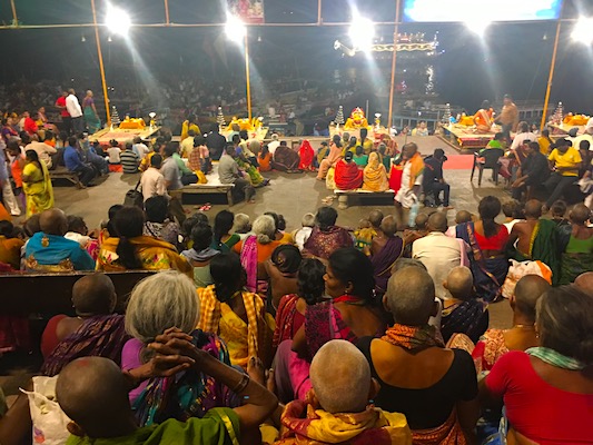 People sitting on the steps attending the Ganga Aarti ceremony at Dashashwamedh Ghat